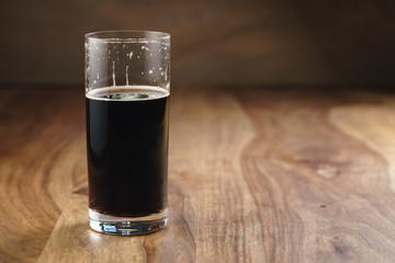 dark beer in glass on wood table