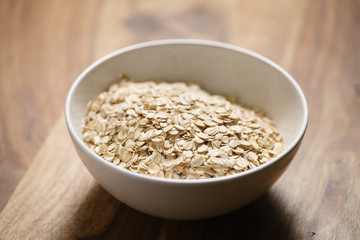 oat flakes in white bowl on wood table