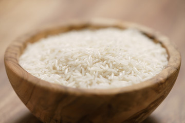dry basmati rice in wood bowl on table