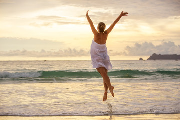 Obraz premium Young woman plays at the sea