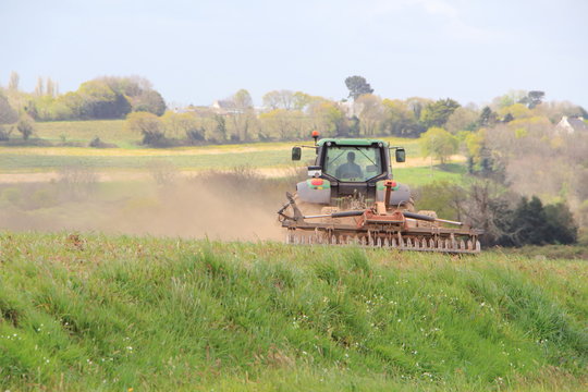 Tracteur passant la herse &agrave; disques dans un champ