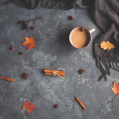 Fototapeta na wymiar Autumn composition. Cup of coffee, scarf, autumn leaves on black background. Flat lay, top view, square