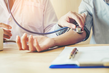 Doctor Measuring arterial blood pressure woman patient on right arm Health care in hospital