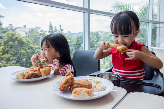 Asian Chinese little girls eating fried chicken
