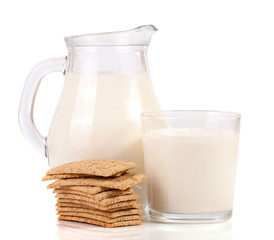 jug and glass of milk with stack of grain crispbreads isolated on white background