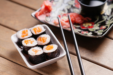 Sushi rolls with salmon, ginger, chopsticks and soy sauce 