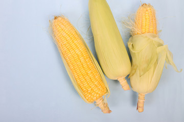 Fresh corn on cobs on texture background, closeup, top view
