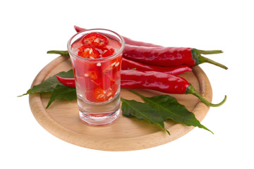 Slices of preserved red hot pepper in glass isolated on a white background