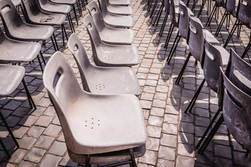 row of old aged chairs in the ceremony concert day in day light