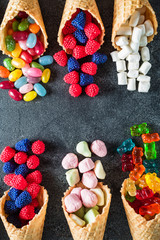Assorted candy in waffle cones. Summer sweet concept. Flat lay, top view