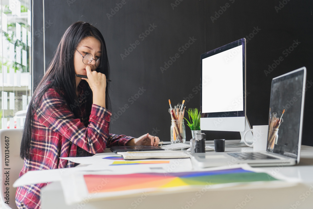 Aufkleber female graphic designer working on computer while using graphic tablet at desk in the office