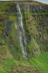 Fototapeta na wymiar Huge waterfall off the side of a mountain in Iceland