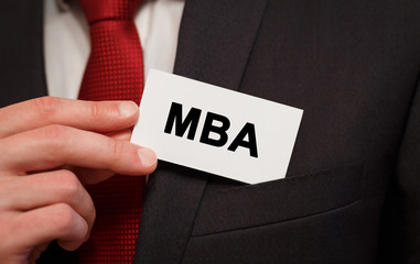 Businessman putting a card with text MBA in the pocket