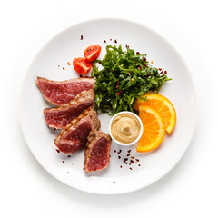 Fillet mignon - grilled beefsteaks with vegetables on white background 