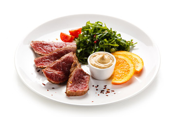 Fillet mignon - grilled beefsteaks with vegetables on white background 