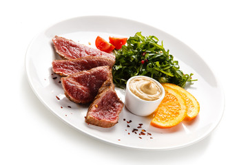 Fillet mignon - grilled beefsteaks with vegetables on white background 
