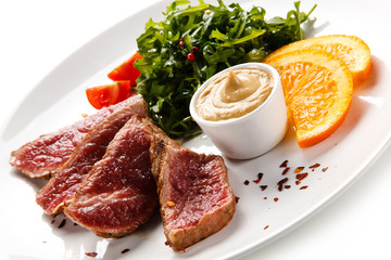 Fillet mignon - grilled beefsteaks with vegetables on white background 