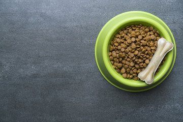 Dog bone and dog food on black background