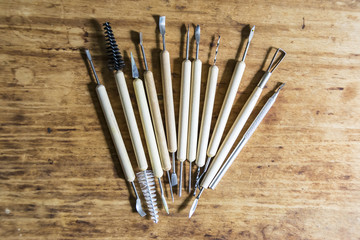 Tools for working with clay modeling on a wooden background in a workshop