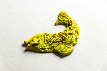 Handmade Figurine made of clay, plasticine on a wooden background