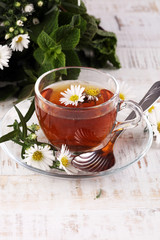 cup of tea with chamomile flowers on rustic background