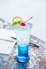 Blue italian soda with cherry on top in high shape glass
