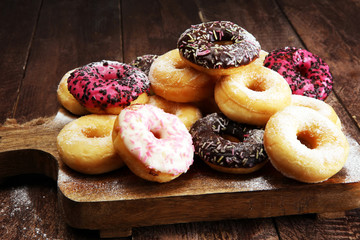 assorted donuts with chocolate frosted, pink glazed and sprinkles donuts.