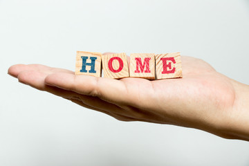 Man hold wood block with wording home on concrete background