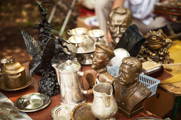 USSR famous historic persons busts and metal tableware at a flea market. Many old vintage things at...
