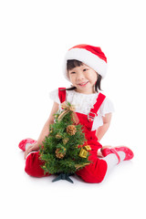 Little asian cute girl wearing santa dress sitting on the floor with christmas tree