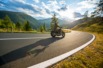 Fototapeta premium Motorcycle driver riding in Alpine highway, Nockalmstrasse, Austria, Europe.