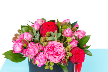 Close up of gallant bouquet of pink and red roses and red ribbon in a circular black box