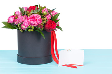 Beautiful bouquet of pink and red roses with a blank gift tag with copy space