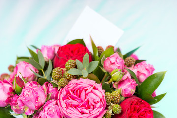 Close up of stylish bouquet of pink and red roses with a blank gift tag with copy space