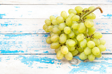 Bunch of fresh ripe green grapes on a old wooden table.