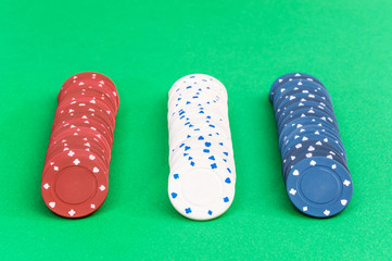 Rows of poker chips on a green background.