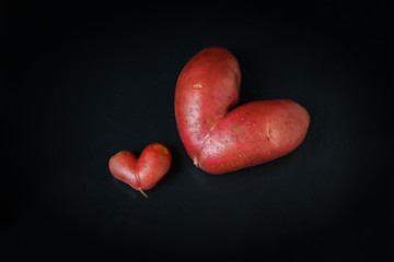 Heart shaped red Potato on a black