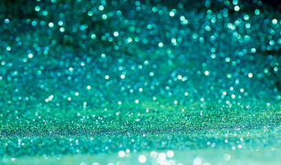 green Sparkling Lights Festive background with texture. Abstract Christmas twinkled bright bokeh...