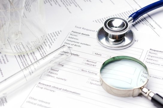 Stethoscope, Magnifying Glass, Test Tube, Beaker And Patient Information Form On Desk, Healthcare Technology, Medical Report Record And History Patient Concept, Selective Focus