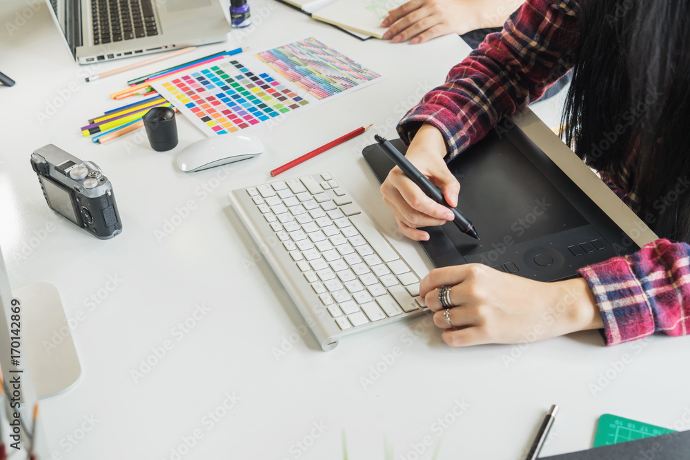 Poster graphic designer using digital tablet and computer in the office