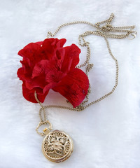Flower red rose and gold filigree work clock - pendant with lid lay on white fur
