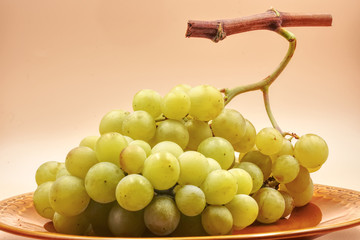 Bunch of white green grapes with light orange background. HDR effect.