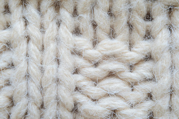The texture of fabric thick beige sweater close-up. Knitted texture background