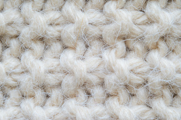 The texture of fabric thick beige sweater close-up. Knitted texture background