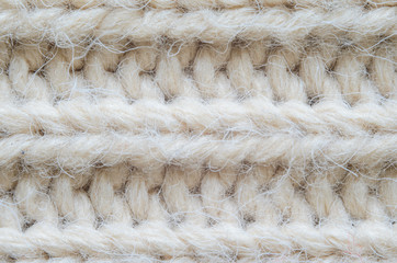The texture of fabric thick beige sweater close-up. Knitted texture background