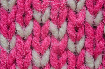 Texture of a beige and red knitted sweater close-up. Abstract pattern on winter knitted clothes
