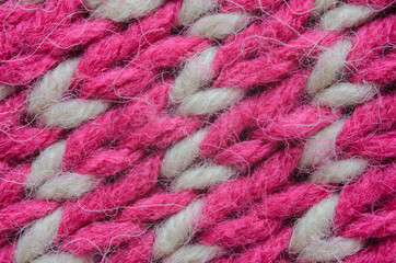 Texture of a beige and red knitted sweater close-up. Abstract pattern on winter knitted clothes