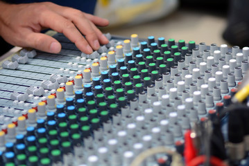The remote sound engineer. Remote control of the sound engineer shallow depth of field. The DJ uses...