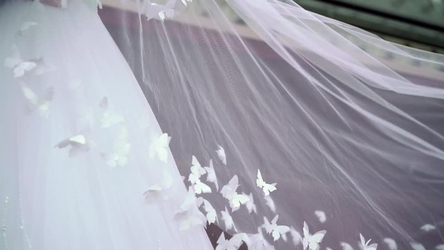 Wedding couple hugging, veil waving at cloudy day