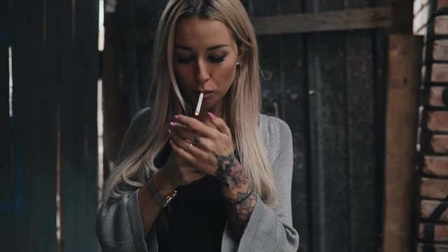 Bad addiction. Woman smoke a cigarette in a side street.